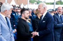 Tổng thống Joe Biden (phải) bắt tay Tổng thống Ukraine Volodymyr Zelenskyy trong buổi lễ quốc tế tại Bãi biển Omaha, hôm 06/06/2024, đánh dấu kỷ niệm 80 năm sự kiện D-Day của quân đồng minh đổ bộ vào Normandy, ở Saint-Laurent-sur-Mer, tây bắc nước Pháp thời Đệ nhị Thế chiến. (Ảnh: Ludovic Marin/AFP qua Getty Images)
