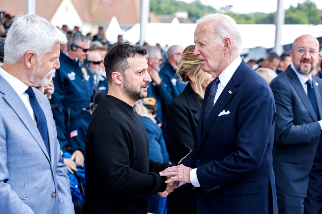 Tổng thống Joe Biden (phải) bắt tay Tổng thống Ukraine Volodymyr Zelenskyy trong buổi lễ quốc tế tại Bãi biển Omaha, hôm 06/06/2024, đánh dấu kỷ niệm 80 năm sự kiện D-Day của quân đồng minh đổ bộ vào Normandy, ở Saint-Laurent-sur-Mer, tây bắc nước Pháp thời Đệ nhị Thế chiến. (Ảnh: Ludovic Marin/AFP qua Getty Images)