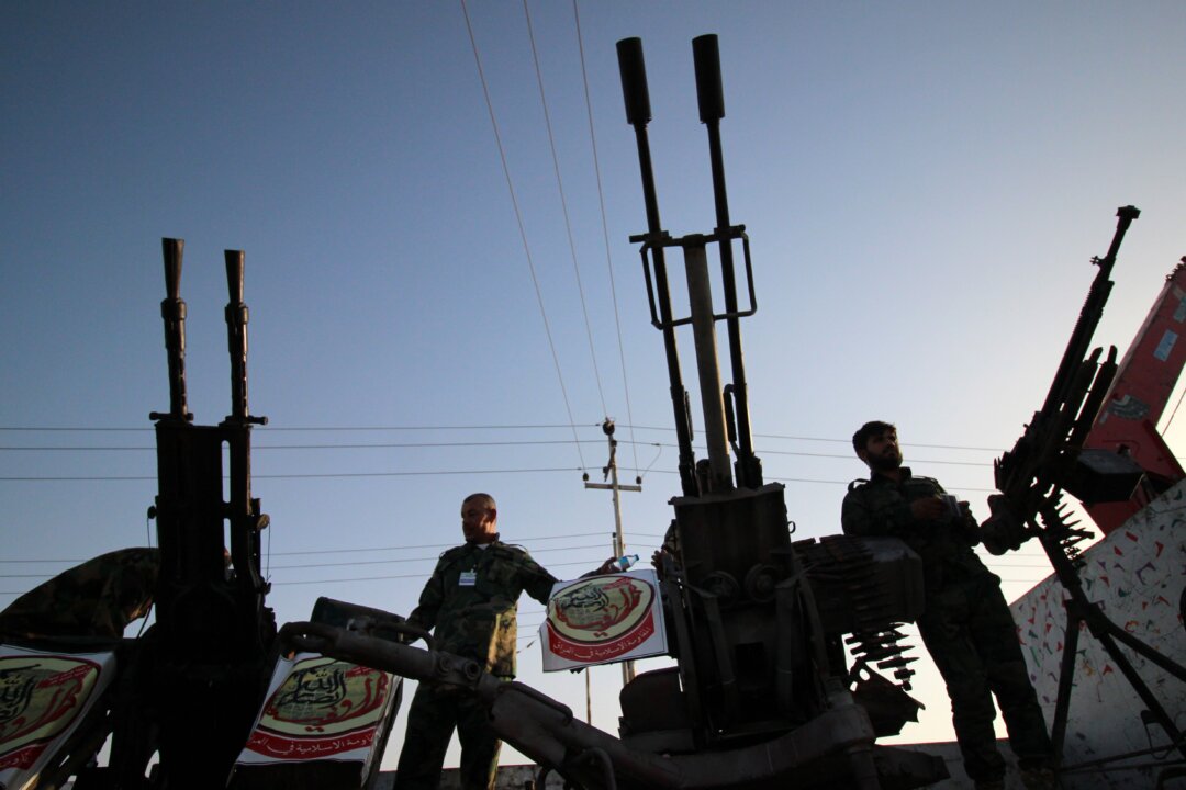 Các tay súng của nhóm Harakat Ansar Allah al-Awfiya Shiite tuần hành với vũ khí ở thành phố Basra, miền nam Iraq, ngày 16/06/2015. (Ảnh: Haidar Mohammed Ali/AFP qua Getty Images)