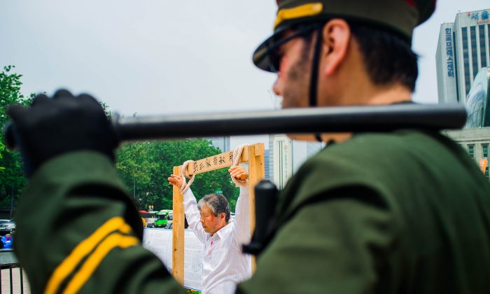 Những người biểu tình tái hiện các hành vi vi phạm nhân quyền diễn ra tại các nhà tù Trung Quốc tại một sự kiện tại Seoul Plaza, Nam Hàn, vào ngày 20/07/2014, nhằm nâng cao nhận thức về cuộc bức hại Pháp Luân Công ở Trung Quốc. (Ảnh: Jarrod Hall/Epoch Times)