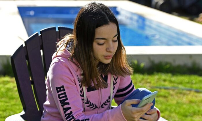 Một học sinh trung học người Argentina sử dụng điện thoại di động tại sân nhà của mình ở La Plata, Buenos Aires, Argentina, vào ngày 28/07/2020. (Ảnh: Juan Mabromata/AFP qua Getty Images)