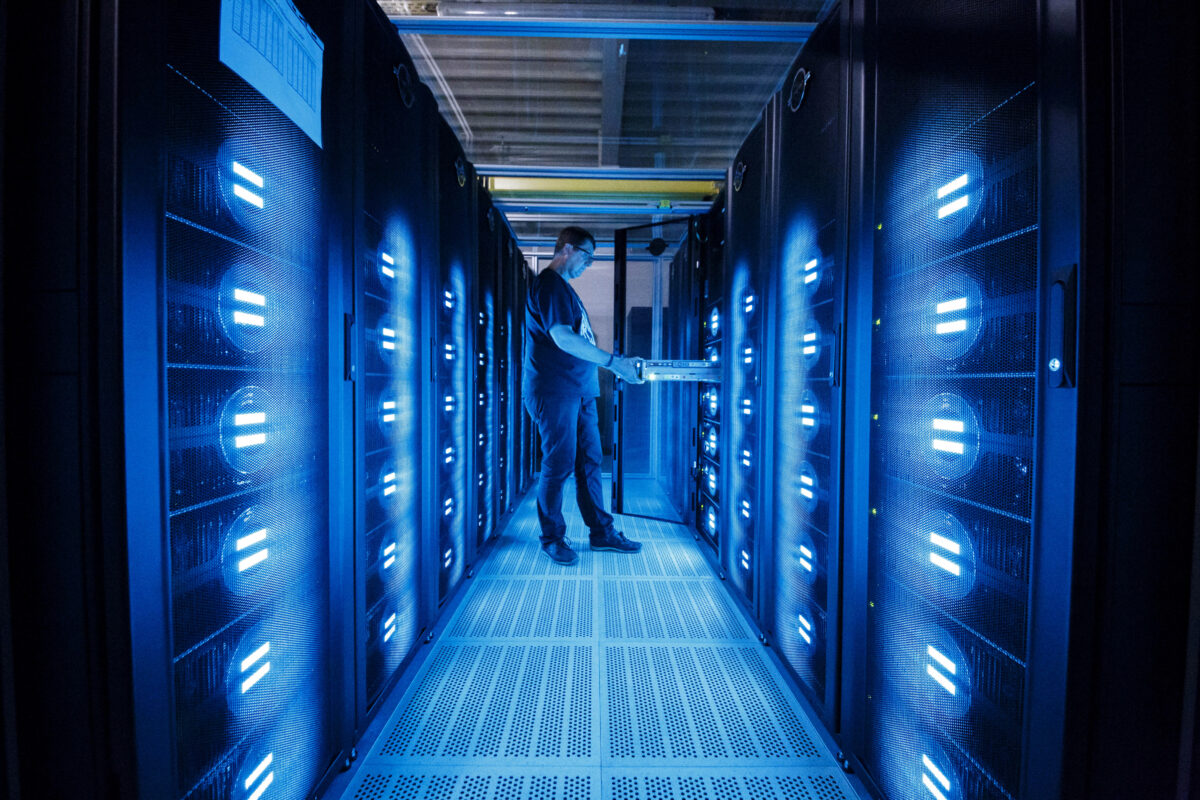 Một nhân viên của Trung tâm Điện toán Khí hậu Đức (DKRZ, hay Deutsches Klimarechenzentrum) bên cạnh siêu máy điện toán “Mistral,” được lắp đặt năm 2016, tại Trung tâm Điện toán Khí hậu Đức vào ngày 07/06/2017, ở Hamburg, Đức. (Ảnh: Morris MacMatzen/Getty Images)