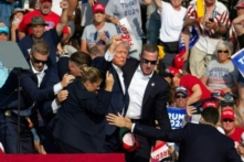 Ông Trump đã đồng ý tiếp nhận phỏng vấn từ Cục Điều tra Liên bang (FBI). Hình ảnh cựu Tổng thống Hoa Kỳ, ứng cử viên Tổng thống năm 2024 của Đảng Cộng Hòa, ông Donald Trump, đã bị bắn và bị thương ở vành tai, được nhân viên Mật vụ hộ tống ra khỏi hiện trường, tại một cuộc vận động tranh cử ở thành phố Butler, Pennsylvania, hôm 13/07/2024. (Ảnh: Rebecca Droke/AFP qua Getty Images)