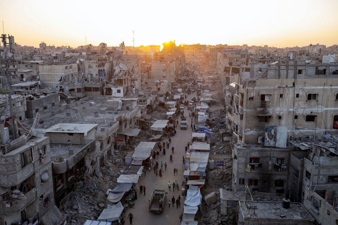 Những người Palestine phải di dời do cuộc oanh tạc của Israel vào Dải Gaza đi bộ qua một khu chợ trời ở Khan Younis, phía nam Dải Gaza, hôm 29/06/2024. (Ảnh: Jehad Alshrafi/AP Photo)