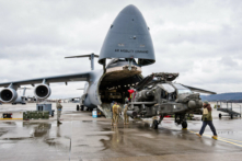 Một chiếc trực thăng tấn công Apache đang được dỡ xuống từ một phi cơ vận tải Galaxy C-5 tại Căn cứ Không quân Hoa Kỳ ở Ramstein, miền Tây nước Đức, vào ngày 22/2/2017. Những chiếc trực thăng tấn công đầu tiên của Quân đội Hoa Kỳ, dự định sẽ được khai triển trong cuộc tập trận quân sự với các đối tác NATO trong chiến dịch “Atlantic Resolve,” đã đến một điểm dừng chân ở Ramstein. (Ảnh: Martin Goldhahn/AFP/Getty Images)