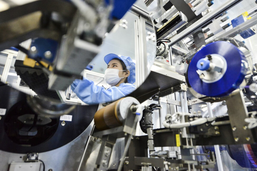 Hình ảnh phản chiếu của một công nhân lên khung gương của một dây chuyền sản xuất pin lithium-ion tại một nhà máy ở thành phố Hồ Châu, Trung Quốc. Nhà máy này thuộc sở hữu của Microvast Holdings, có công ty con có trụ sở tại Texas đủ điều kiện đàm phán về khoản tài trợ trị giá 200 triệu USD của Bộ Năng lượng Hoa Kỳ để sản xuất pin lithium ở Hoa Kỳ. (Ảnh: Stringer/Reuters)