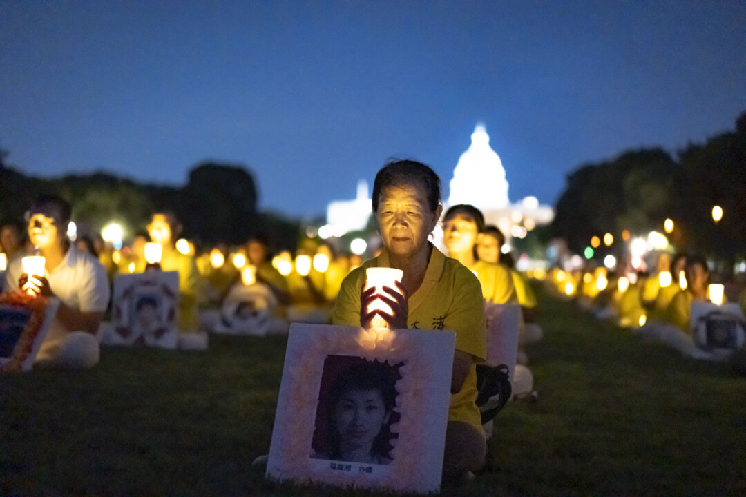 Các học viên Pháp Luân Công tham gia buổi thắp nến tưởng niệm những học viên Pháp Luân Công đã qua đời trong suốt 25 năm diễn ra cuộc bức hại của Đảng Cộng sản Trung Quốc ở Trung Quốc, tại National Mall, Hoa Thịnh Đốn, hôm 11/07/2024. (Ảnh: Madalina Vasiliu/The Epoch Times)