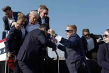 Ứng cử viên tổng thống của Đảng Cộng Hòa, cựu Tổng thống Donald Trump, được các nhân viên Mật vụ Hoa Kỳ hộ tống ra khỏi sân khấu sau khi bị một viên đạn sượt qua trong một cuộc vận động tranh cử hôm 13/07/2024 tại Butler, Pennsylvania. Ông Richard Goldinger, Biện lý quận Butler, cho biết tay súng đã thiệt mạng sau khi làm bị thương cựu Tổng thống Hoa Kỳ Donald Trump, khiến một khán giả thiệt mạng và một người khác bị thương trong vụ xả súng. (Ảnh: Anna Moneymaker/Getty Images)