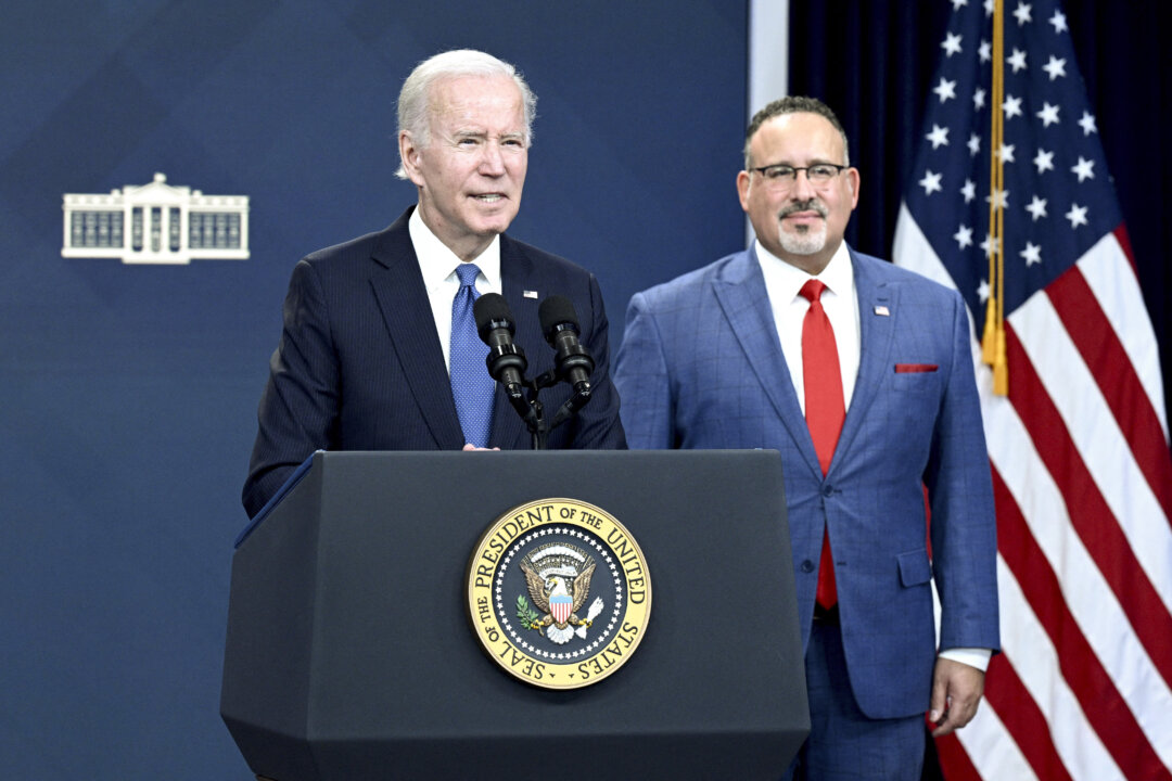 Bộ trưởng Giáo dục Miguel Cardona (bên phải) quan sát khi Tổng thống Joe Biden đưa ra những nhận xét về thử nghiệm beta cổng thông tin xóa nợ thời sinh viên, tại Thính phòng South Court của Tòa nhà Văn phòng Điều hành Eisenhower, bên cạnh Tòa Bạch Ốc ở Hoa Thịnh Đốn, vào ngày 17/10/2022. (Ảnh: Brendan Smialowski/AFP qua Getty Images)