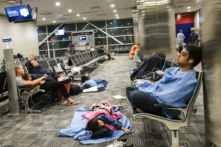 Du khách nghỉ ngơi tại những nơi có thể tại nhà ga McNamara ở Phi trường Detroit Metropolitan Wayne County ở Romulus, Michigan, Hoa Kỳ, hôm 21/07/2024. (Ảnh: Joe Raedle/Getty Images)